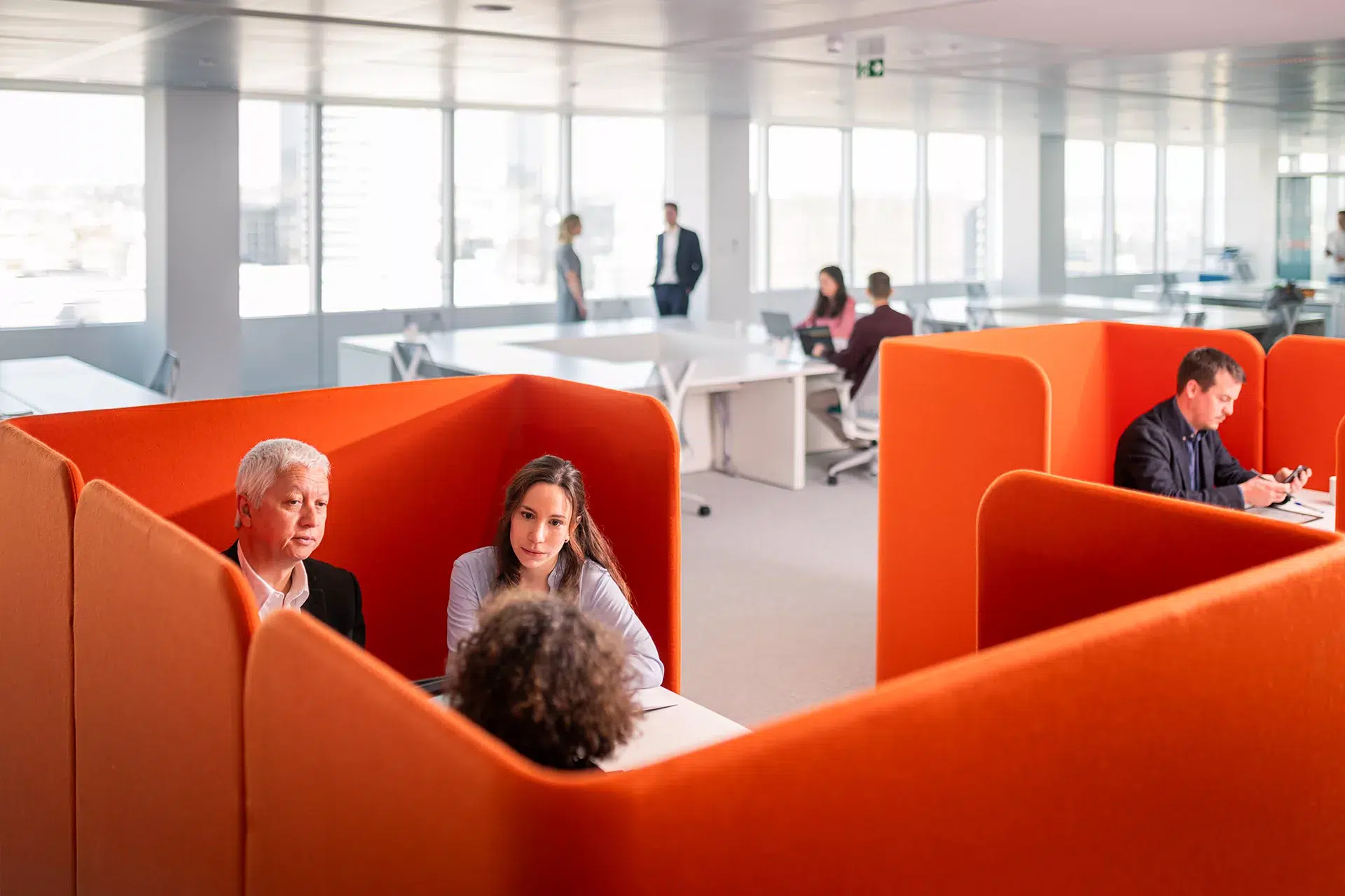 Photographe corporate à Lyon réalisant un reportage en entreprise, collaborateurs en réunion dans des espaces de travail ouverts et colorés pour valoriser la culture d'entreprise.