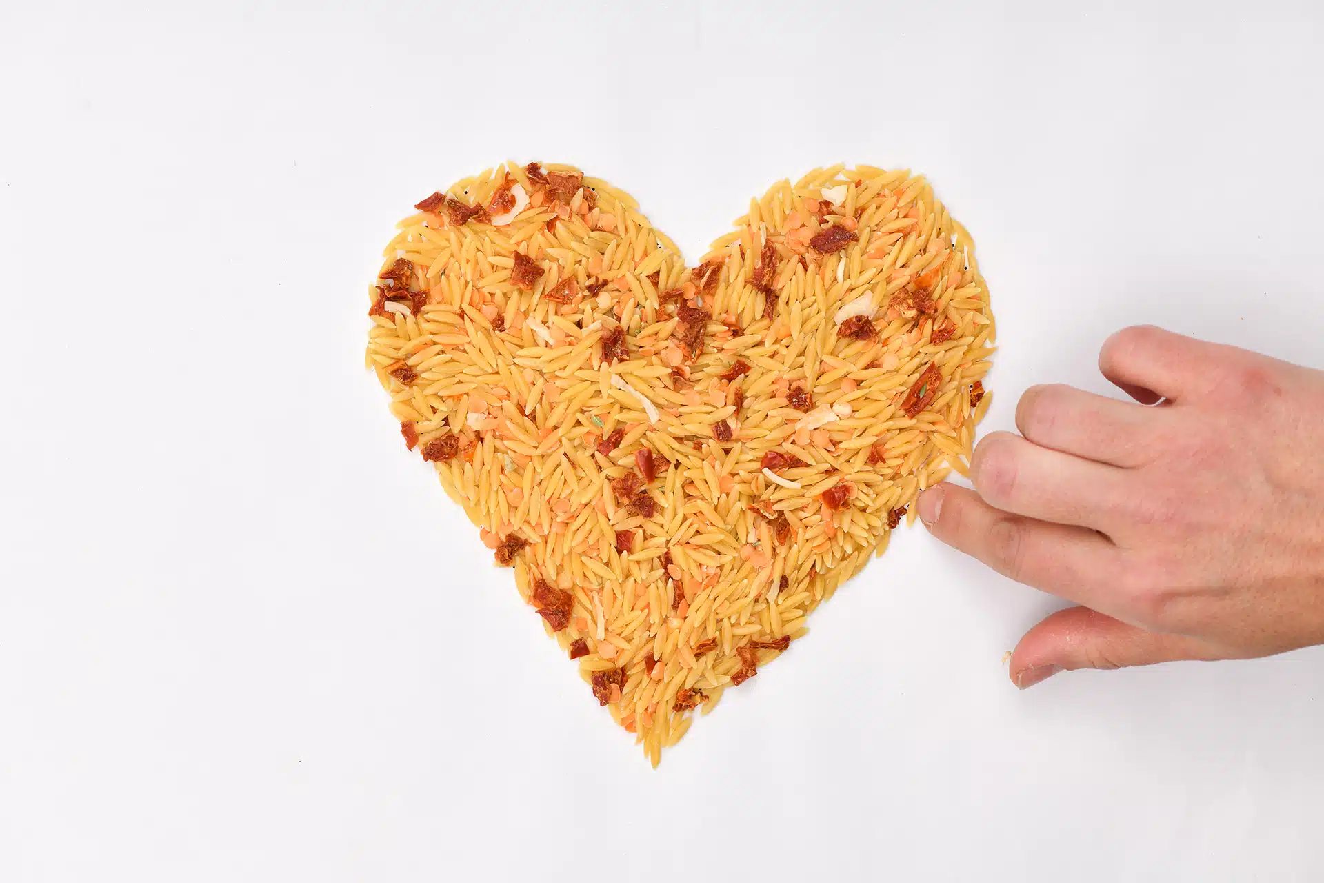 Photographie publicitaire créative en forme de cœur réalisée avec des pâtes.
